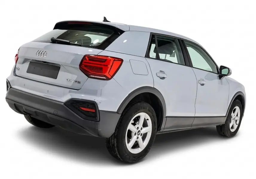 Audi Q2 gris vue 3/4 arrière droit, mettant en valeur ses feux arrière rouges et ses jantes blanches.