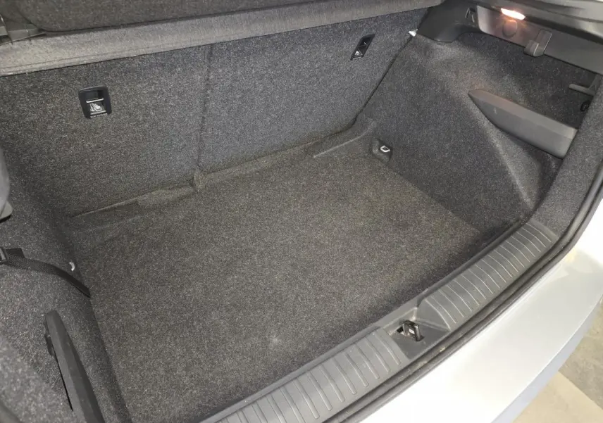 Coffre ouvert vu de dessus du Skoda Kamiq gris 2023, montrant l'espace de chargement vide et les finitions intérieures.