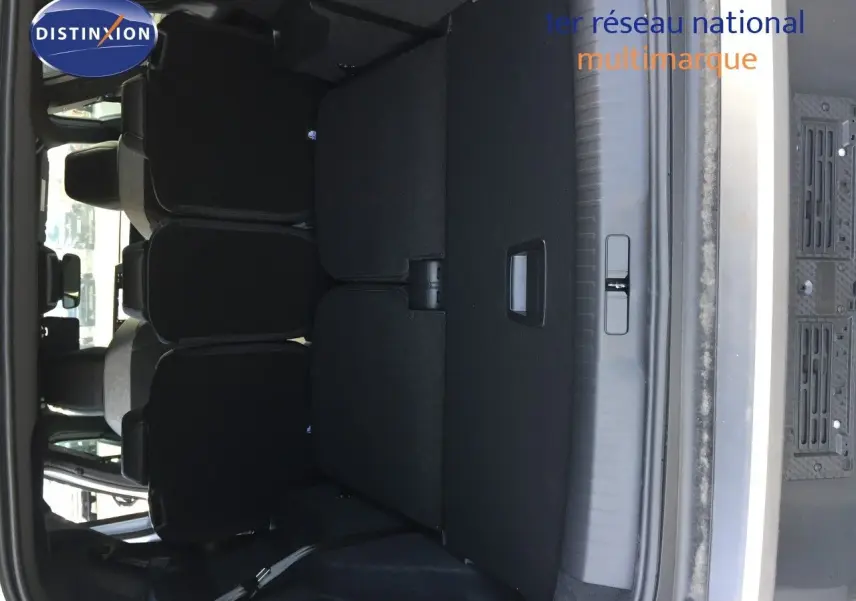 Coffre ouvert du Peugeot 5008 blanc Okenite Metal, montrant la banquette arrière et l'espace de chargement.