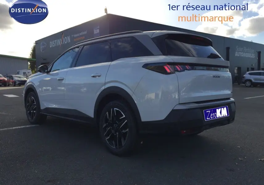 Peugeot 5008 blanc Okenite métal vu de trois quarts arrière droit, avec feux arrière LED et jantes noires distinctives.