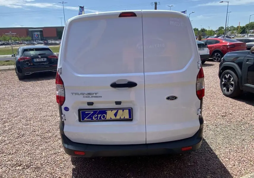 Vue arrière d'un fourgon blanc Ford Tourneo Courier 2022 avec portes battantes et plaque d'immatriculation Zéro KM.
