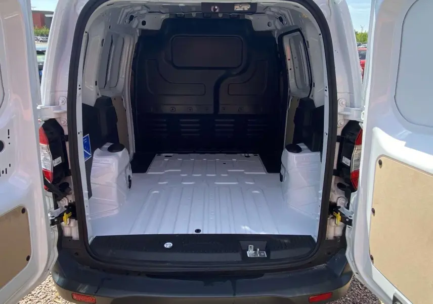 Vue arrière du fourgon blanc Ford Tourneo Courier 2022 avec portes battantes ouvertes dévoilant l'espace de chargement vide.