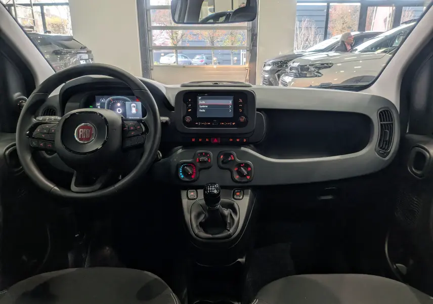 Intérieur de la Fiat Panda 1.0 70 CH Hybrid City 2025, vue frontale du tableau de bord avec écran tactile et boîte manuelle.