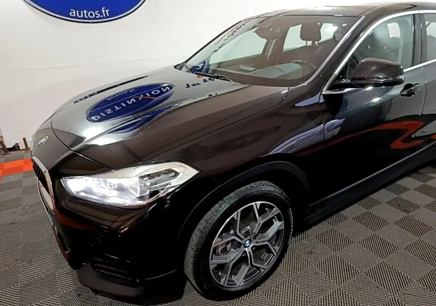BMW X2 sDrive18i Lounge noir vue 3/4 avant droit avec phares LED et jantes alliage distinctives.