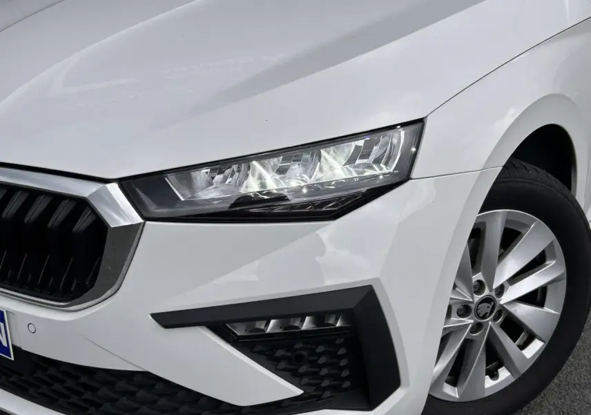 Gros plan sur l'avant droit blanc Candy de la Skoda Scala 2025, mettant en valeur le phare LED et la jante alliage 16 pouces.