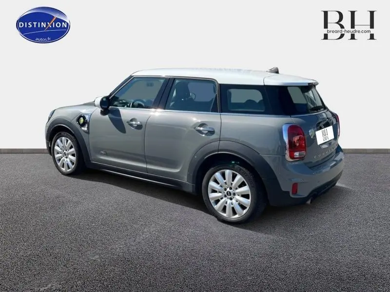 Vue 3/4 arrière droite d'une MINI Countryman Cooper SE Moonwalk Grey avec toit blanc et jantes alu 18 pouces design Pin Spoke.