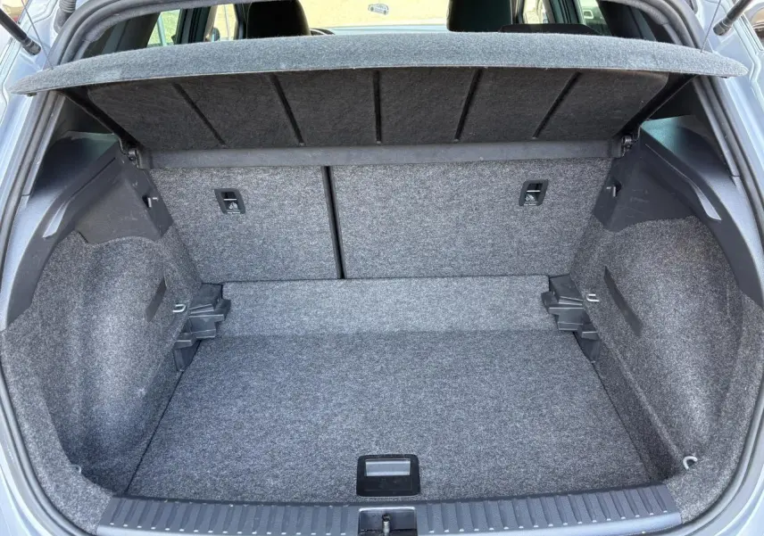 Coffre ouvert vu de l'arrière d'une SEAT Arona 2024, finition FR, avec intérieur gris et plancher plat.