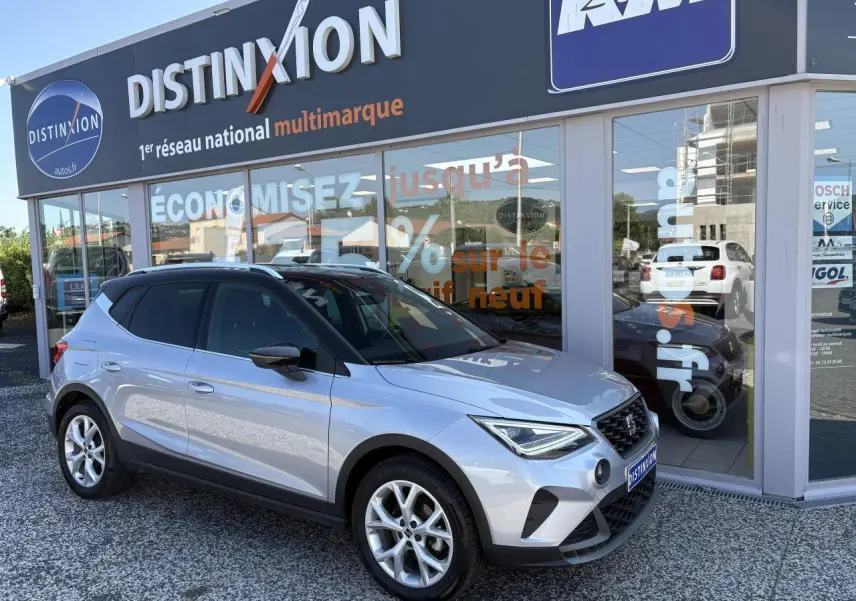 SEAT Arona 2024 gris GRS en 3/4 avant droit, avec jantes alliage 16 pouces et calandre noire distinctive.