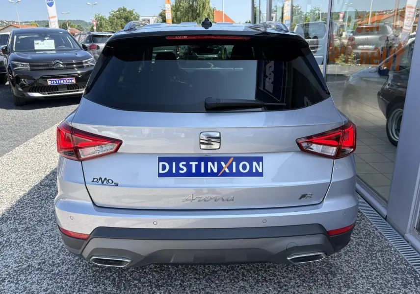 Vue arrière d'un SEAT Arona 2024 gris clair avec logo FR et double sortie d'échappement intégrée au pare-chocs.