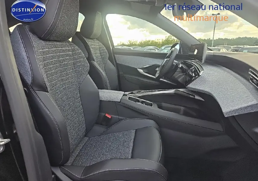 Vue intérieure côté conducteur du Peugeot 3008 noir 2025, sièges bi-matière et tableau de bord moderne avec écran tactile.