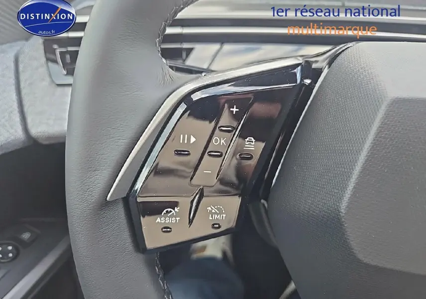 Gros plan sur les commandes multifonctions à gauche du volant cuir du Peugeot 3008 noir 2025 hybride.