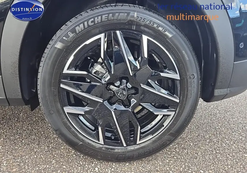 Gros plan sur la jante alu noire et chromée avec logo Peugeot d'un 3008 noir, pneu Michelin 225/55 R19 visible.