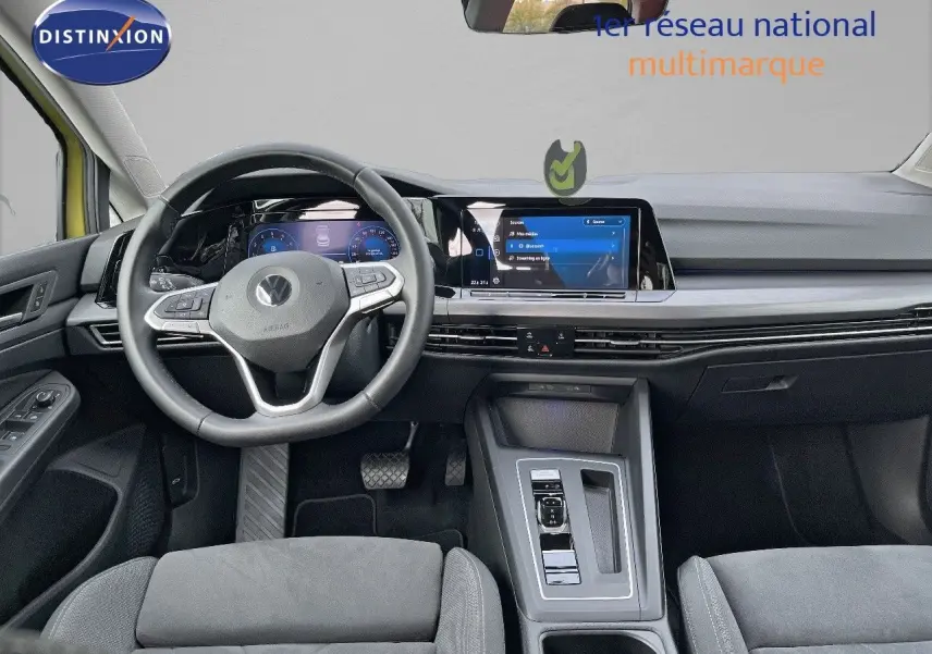 Vue intérieure avant de la Volkswagen Golf jaune 1.5 eTSI 150CH DSG7 STYLE, tableau de bord moderne avec écran tactile central.
