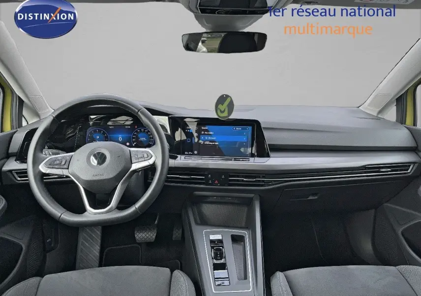 Intérieur moderne de Volkswagen Golf jaune 2020, vue frontale sur tableau de bord et volant multifonction noir.