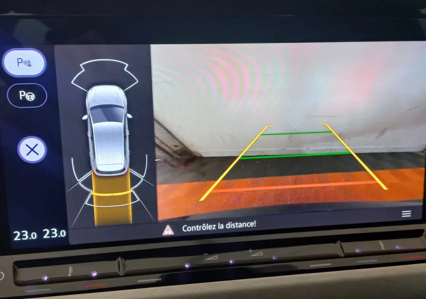 Affichage écran tactile de recul avec vue aérienne et guidage de trajectoire dans une Volkswagen Golf bleue 2022