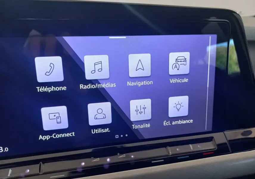 Écran tactile central de la Volkswagen Golf 1.5 bleu, affichant les menus téléphone, navigation et ambiance lumineuse.