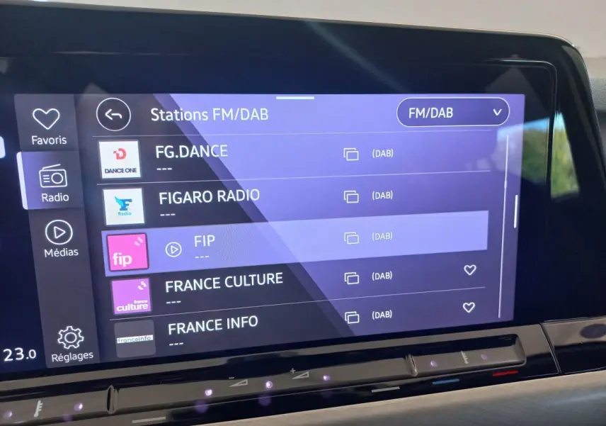 Écran tactile central de la Volkswagen Golf 1.5 bleu, affichant les stations radio FM/DAB avec interface moderne.