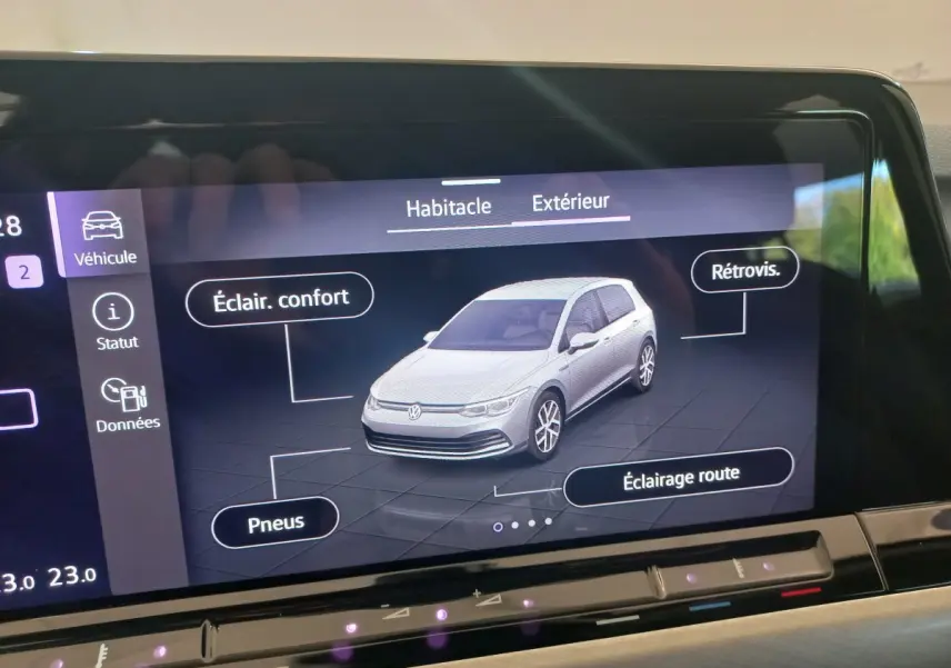 Écran tactile affichant une Volkswagen Golf blanche en 3/4 avant avec options éclairage et pneus visibles