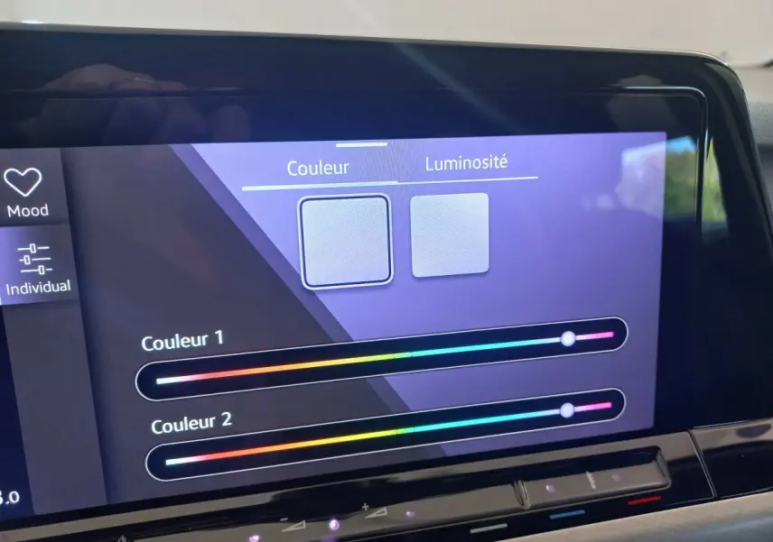 Écran tactile intérieur de la Volkswagen Golf bleu 2022 affichant les réglages de couleur et luminosité de l'ambiance lumineuse.