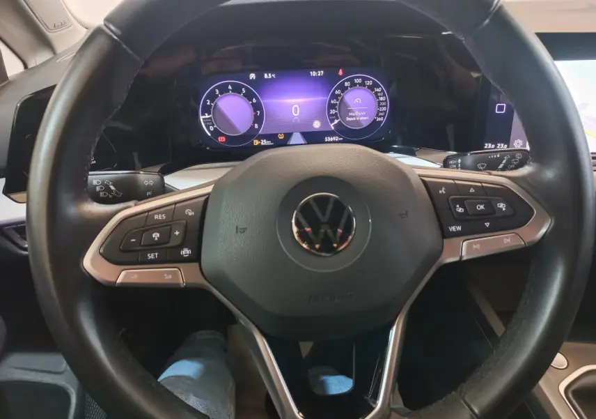Vue intérieure centrée sur le volant cuir et le tableau de bord numérique de la Volkswagen Golf 2022.