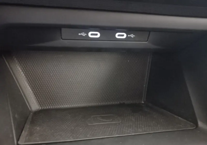 Zone de recharge par induction avec deux ports USB-C éclairés dans une Volkswagen Golf 2022 bleu.