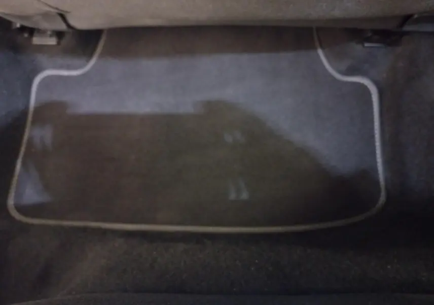 Tapis de sol noir avec surpiqûres claires dans l'habitacle avant d'une Volkswagen Golf bleue 2022.