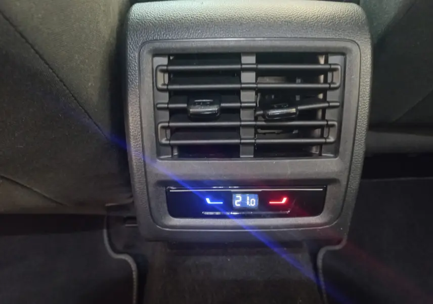 Détail de la commande de climatisation arrière digitale avec diffuseurs d'air noirs dans une Volkswagen Golf bleu 2022.
