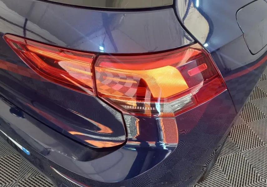 Gros plan sur le feu arrière droit d'une Volkswagen Golf 2022 bleu profond, soulignant ses lignes modernes.