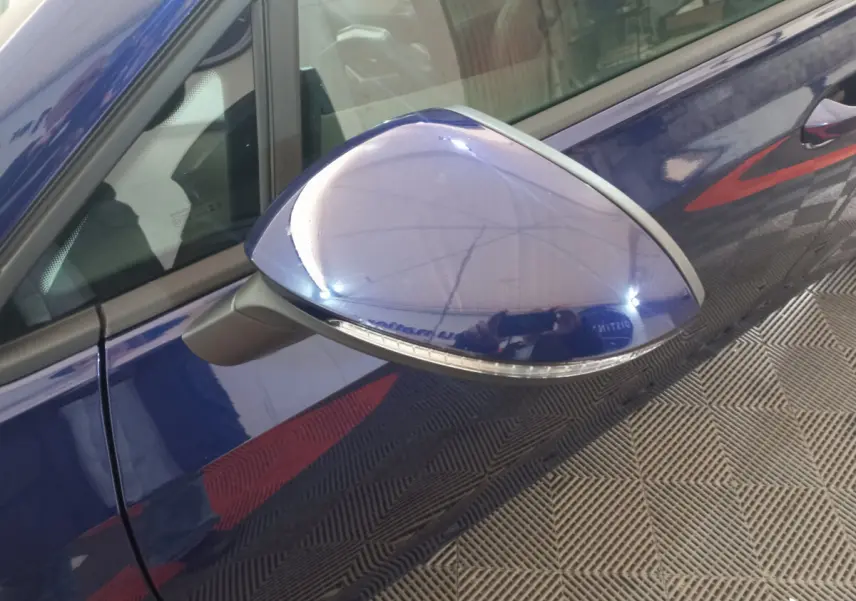 Rétroviseur côté gauche bleu brillant d'une Volkswagen Golf 2022, avec clignotant intégré visible en gros plan.