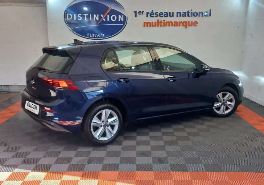 Volkswagen Golf 1.5 essence bleu vue profil côté droit en intérieur avec jantes alliage et feux arrière LED allumés