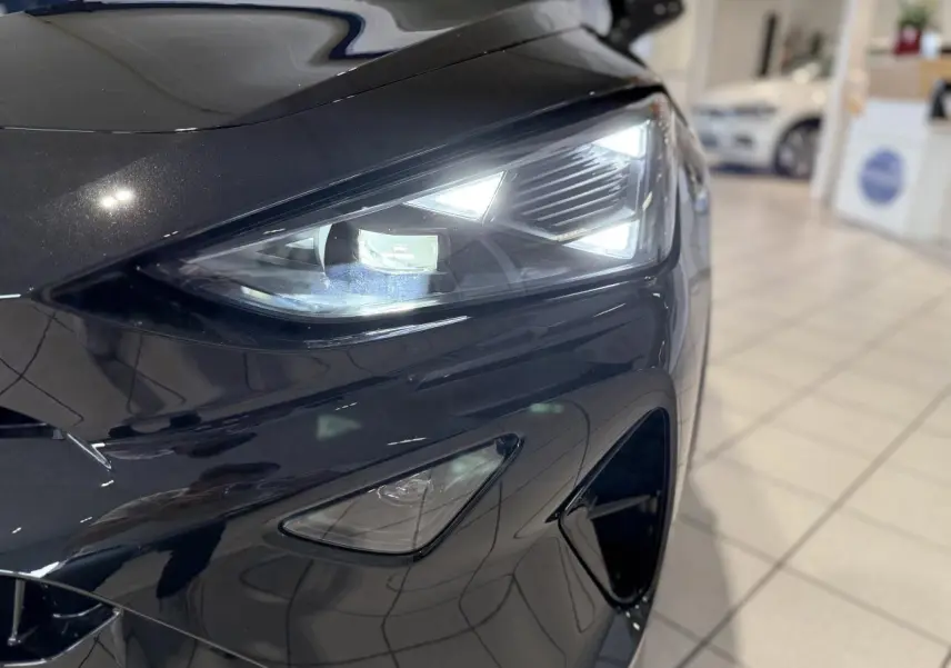 Gros plan sur le phare avant droit du CUPRA Formentor 2.0 TDI noir Night avec détails anguleux et éclairage LED.