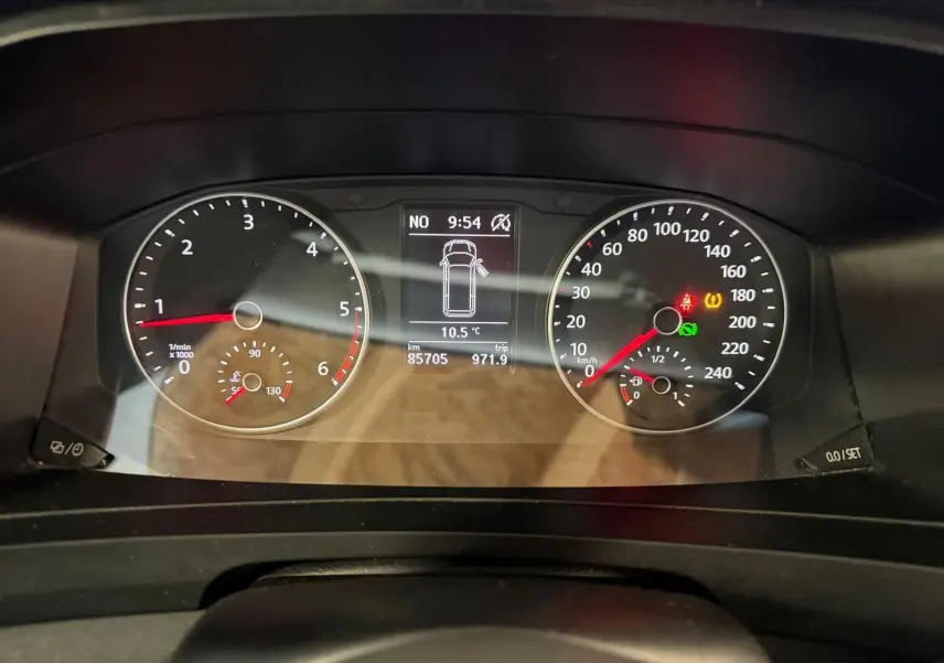 Vue rapprochée du tableau de bord du Volkswagen Transporter blanc, affichant compte-tours, vitesse et écran central numérique.