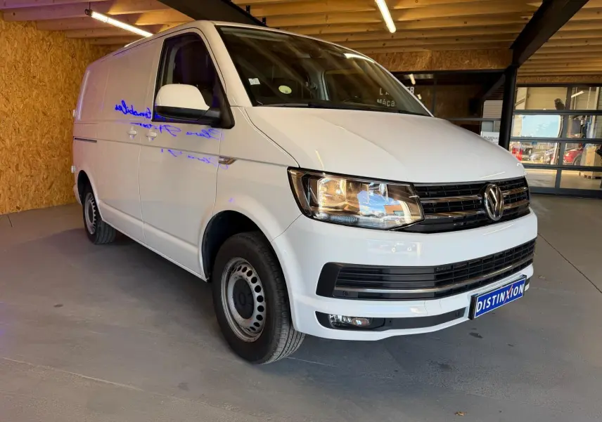 Vue 3/4 avant droit d’un Volkswagen Transporter blanc 2019, utilitaire avec calandre noire et jantes acier.