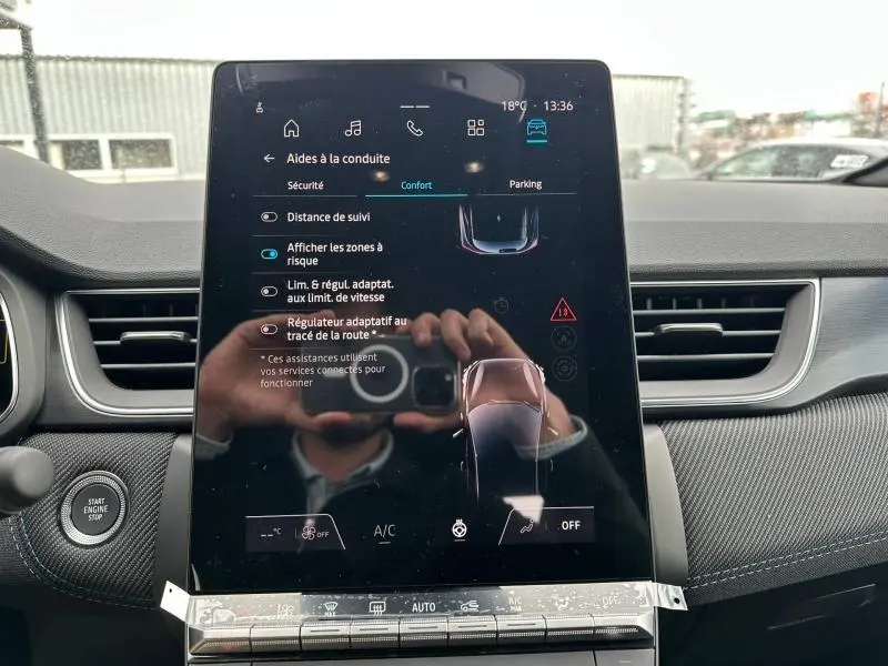 Écran tactile central du Renault Captur 2026 affichant les aides à la conduite, intérieur gris avec détails noirs.