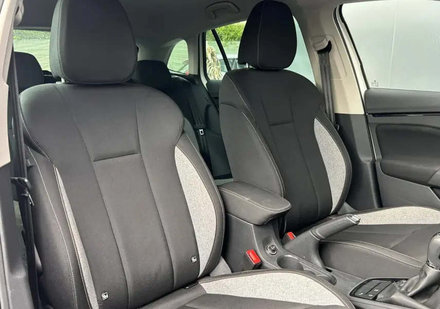 Vue intérieure des sièges avant en tissu noir et gris avec accoudoir central sur une Skoda Scala 2025.
