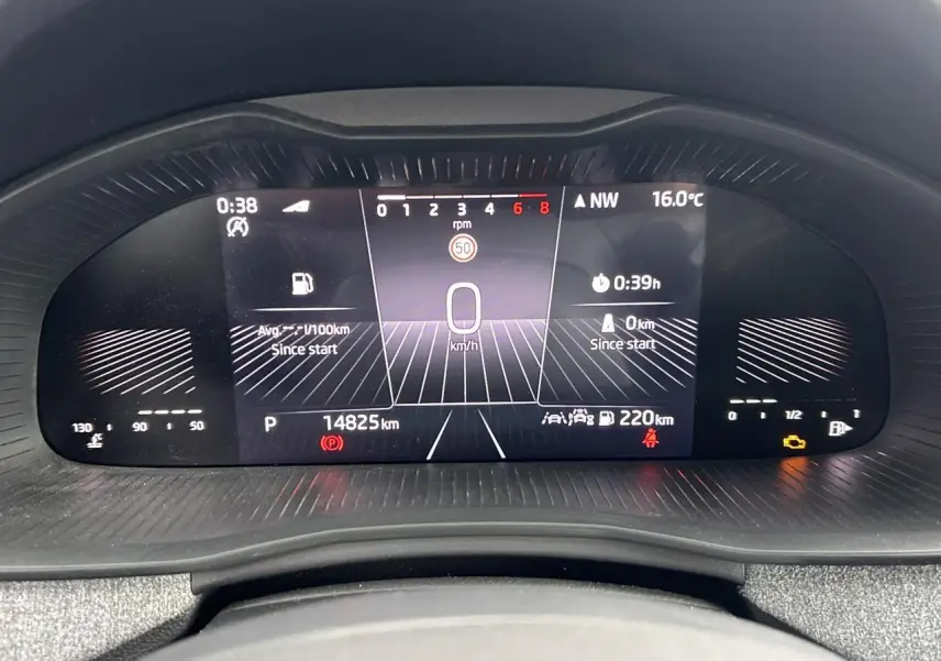 Vue rapprochée du tableau de bord numérique de la Skoda Scala blanc Candy, affichant la vitesse et les informations de conduite.