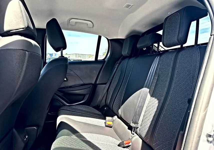 Vue intérieure arrière côté droit de la banquette tissu noir de la Peugeot 208 1.2 100 Allure 2025.