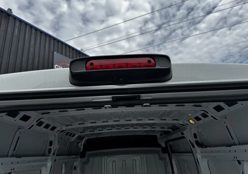 Vue rapprochée de l’arrière intérieur blanc du Peugeot Boxer Fourgon L2H2 avec feu stop et caméra de recul intégrée.