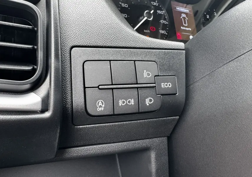 Gros plan sur les commandes noires du tableau de bord côté conducteur du Peugeot Boxer Fourgon blanc, avec affichage du compteur partiel.
