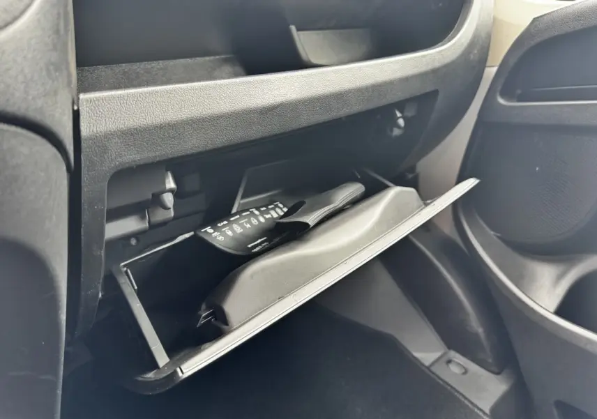 Vue intérieure du coffre à gants ouvert côté passager du Peugeot Boxer Fourgon blanc, avec manuel visible.