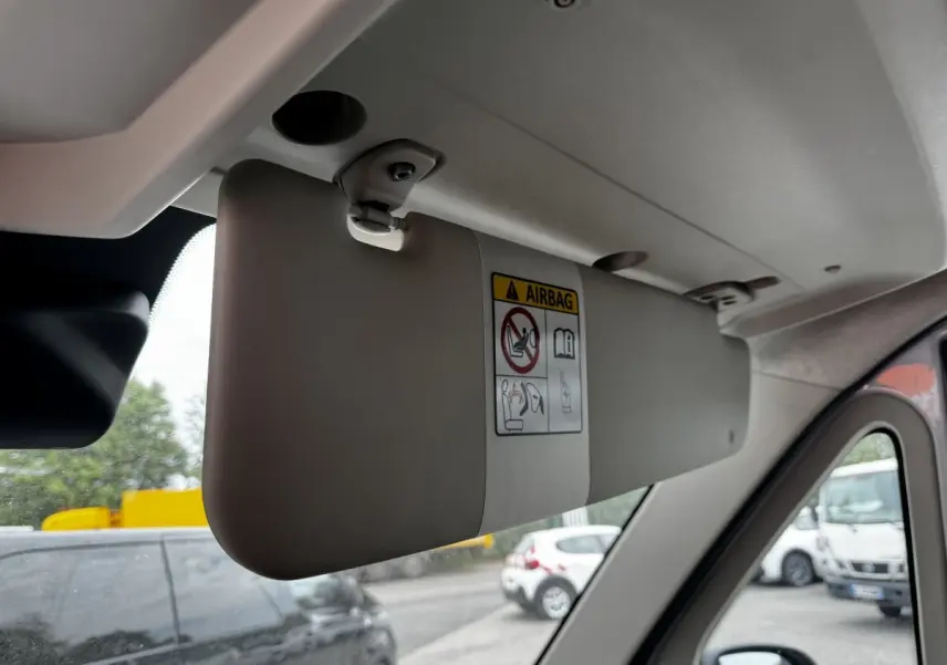 Vue intérieure sur le pare-soleil gris clair côté conducteur du Peugeot Boxer Fourgon blanc, avec avertissement airbag visible.