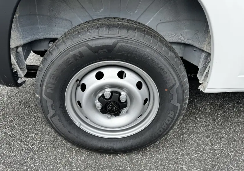 Gros plan sur la roue avant droite du Peugeot Boxer Fourgon blanc, avec jante acier et logo Peugeot au centre.