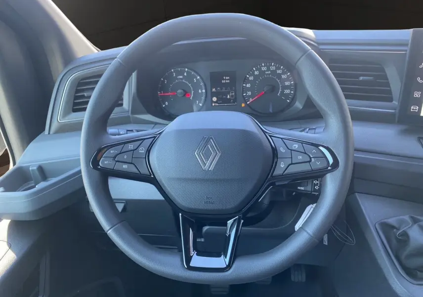 Vue frontale du volant noir du Renault Master 2025 avec commandes intégrées et tableau de bord gris.