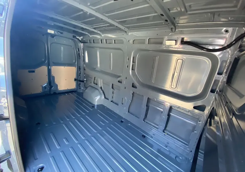 Intérieur de la zone de chargement du Renault Master gris urbain, vue depuis l'arrière avec portes ouvertes.