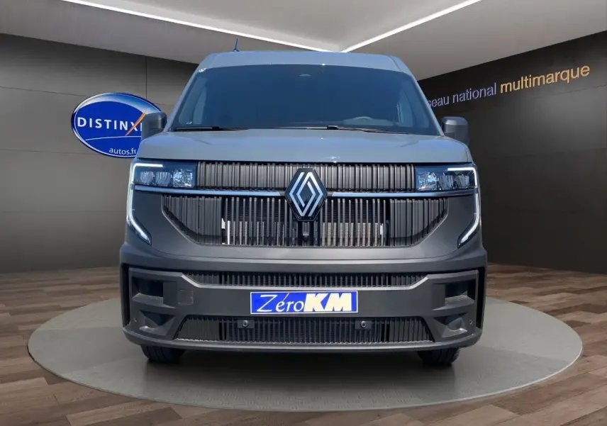 Vue de face du Renault Master 2025 gris urbain avec calandre noire et phares LED intégrés, en showroom.