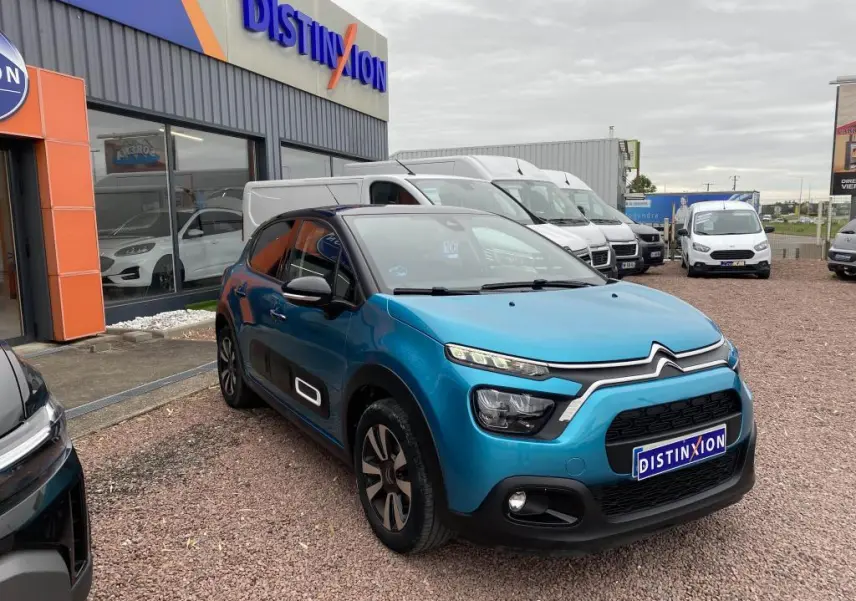 Citroën C3 2023 bleu Spring Azul avec toit noir, vue 3/4 avant sur parking devant concession Distinxion.