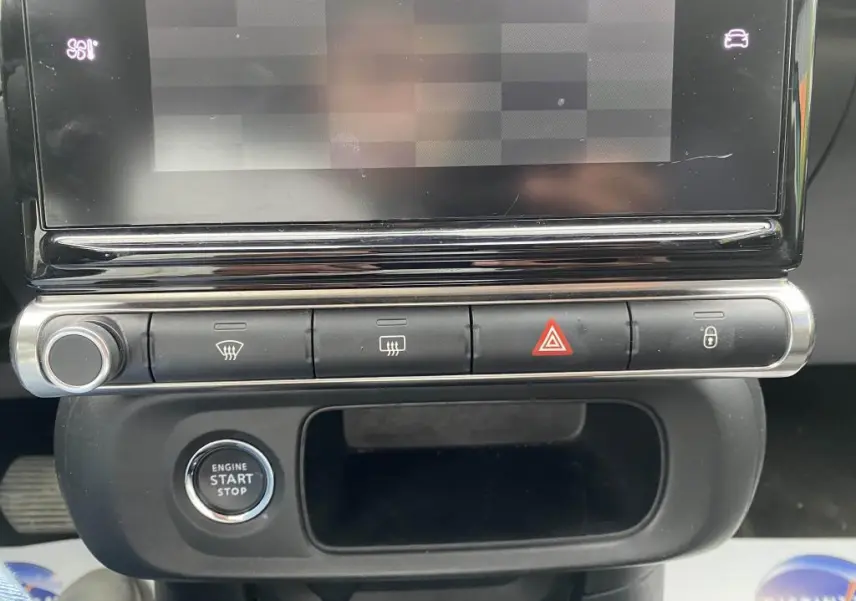 Gros plan sur la console centrale de la Citroën C3 2023, montrant les boutons de commande et le bouton start/stop.