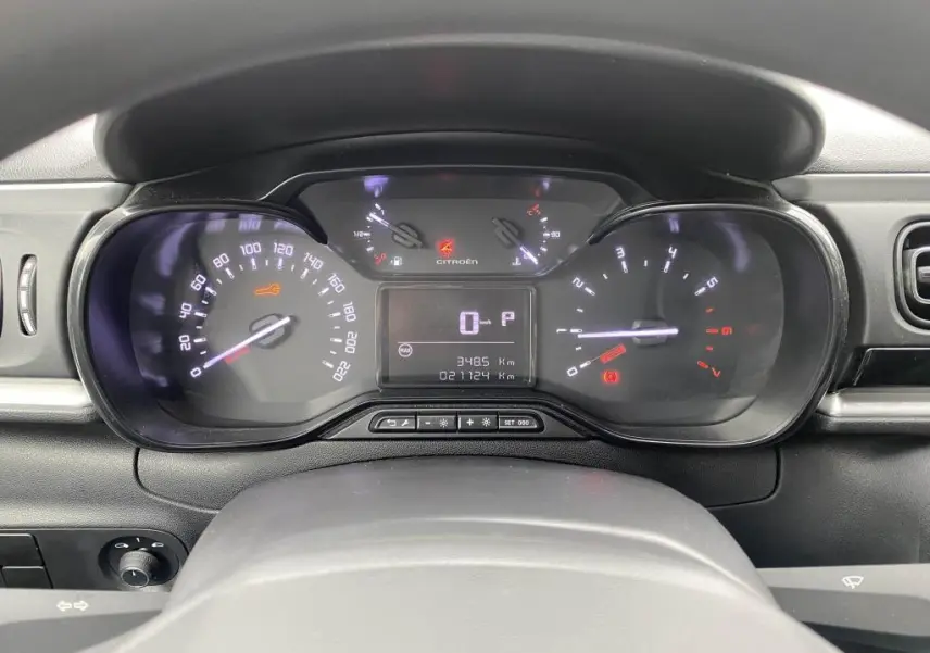 Tableau de bord de Citroën C3 2023 en vue frontale, affichant compteurs numériques et témoins lumineux allumés.