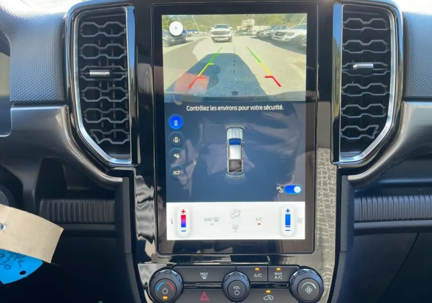 Vue rapprochée de l'écran central tactile du Ford Ranger gris iconic 2025 affichant la caméra de recul et les commandes climatisation.