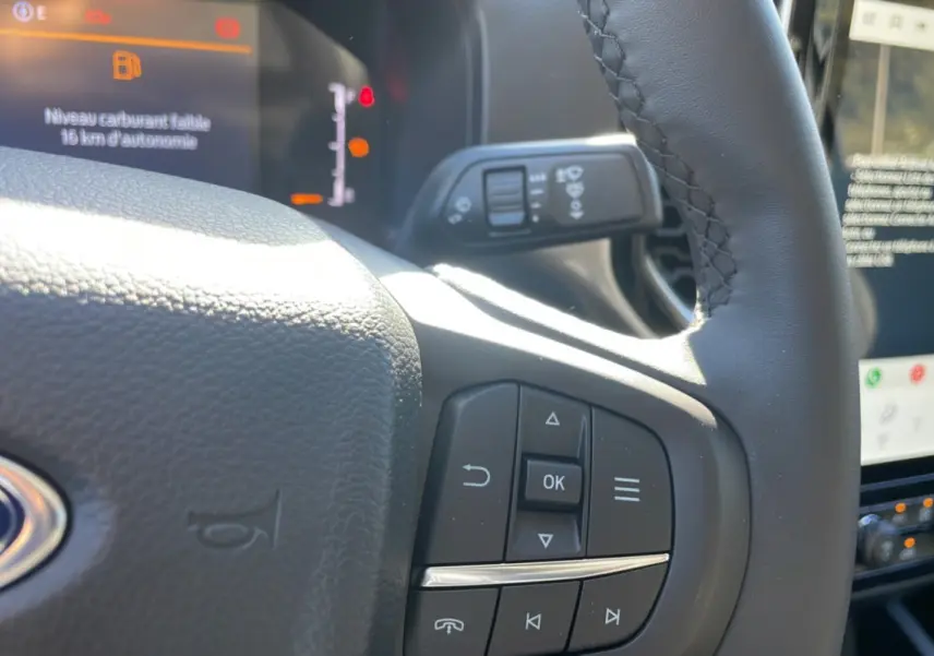 Détail du volant côté gauche du Ford Ranger 2025 gris iconic avec commandes intégrées et tableau de bord numérique.